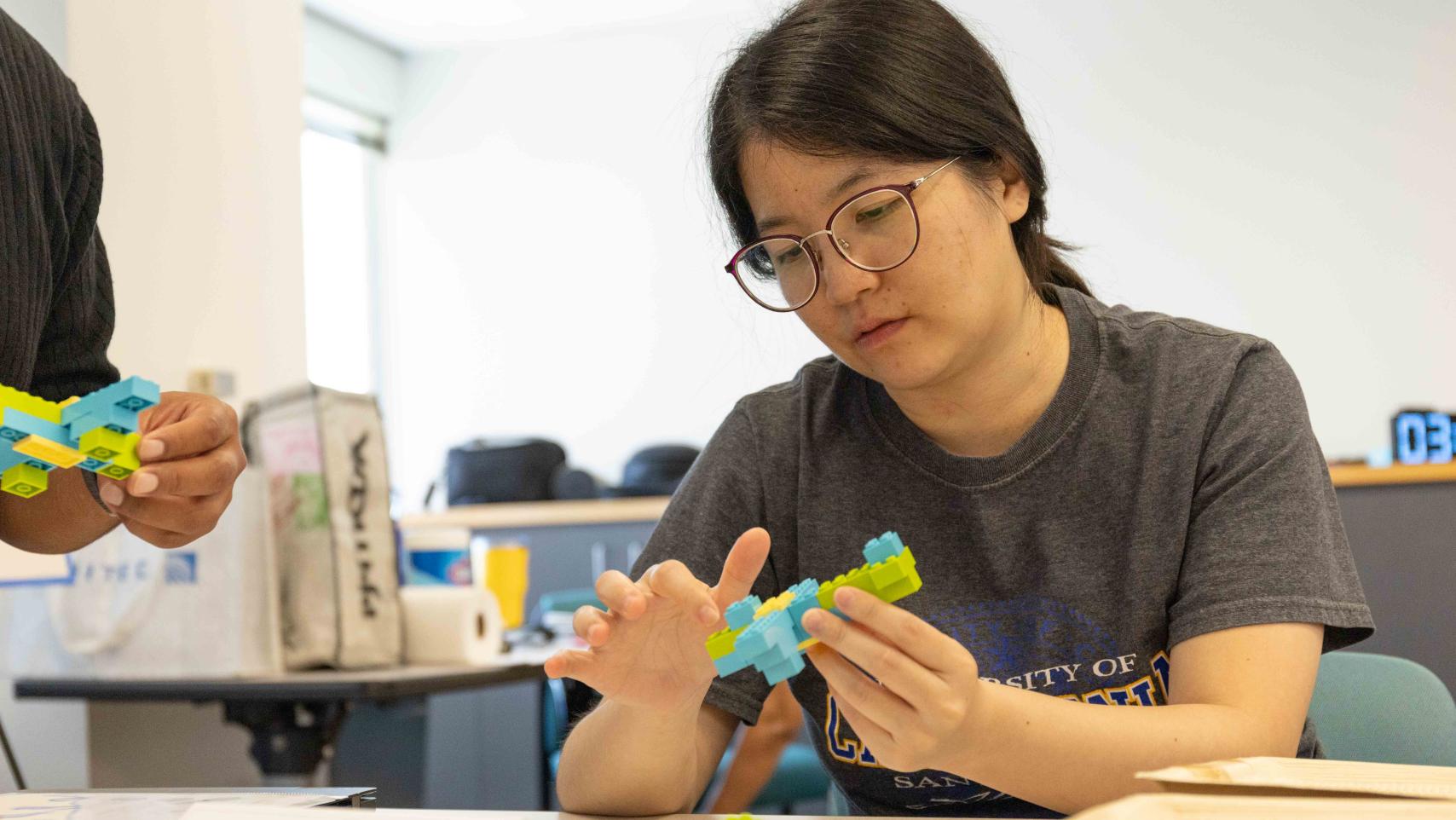 Female Lean Sigma Six participant looking at a Lego model in her hands